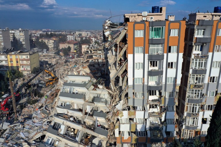 Cranes remove debris next to destroyed buildings in Antakya, southeastern Turkey.