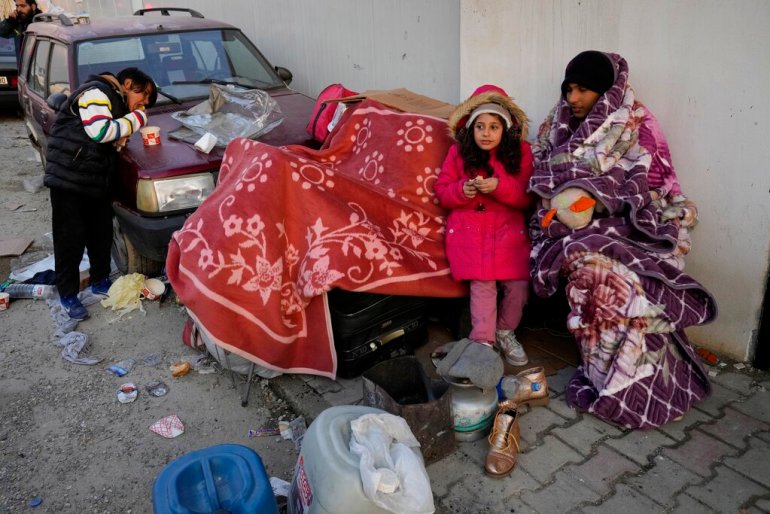 Suriyeliler, 10 Şubat 2023 Cuma günü Türkiye'nin güneydoğusundaki Antakya'daki bir sığınakta toplanıyor. Suriyeli gönüllülerden oluşan bir ekip olan Molham tarafından işletilen sığınak, depremden hemen sonra kuruldu.  Yıllar önce memleketlerinde patlak veren savaşın ardından kaçan ve şimdi kendilerini bir kez daha yerinden edilmiş ve evsiz bulan yüzbinlerce Suriyeli mülteciye geçici barınak, sıcak yemek ve harap şehirden ulaşım imkanı sağladı.  (AP Fotoğrafı/Hüseyin Malla)