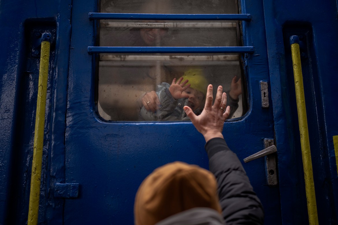 Stanislav says goodbye to his 2-year-old son, David, and wife, Anna, after they boarded a train that will take them to Lviv, from the station in Kyiv