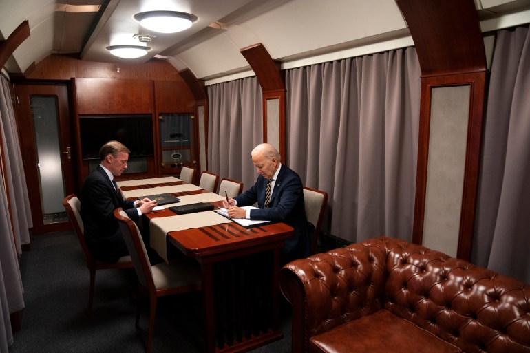 President Joe Biden sits on a train with National Security Advisor Jake Sullivan