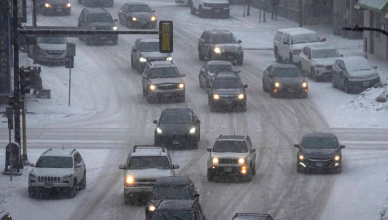 Cars navigate a snowy highway in downtown Minneapolis