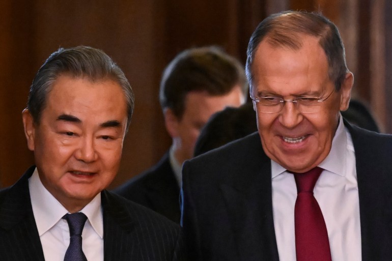 Sergei Lavrov smiles as he guides Wang Yi to his room in the Kremlin. The king looks very relaxed. Both are in suits.