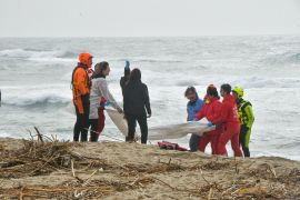 Rescuers recover a body after a migrant