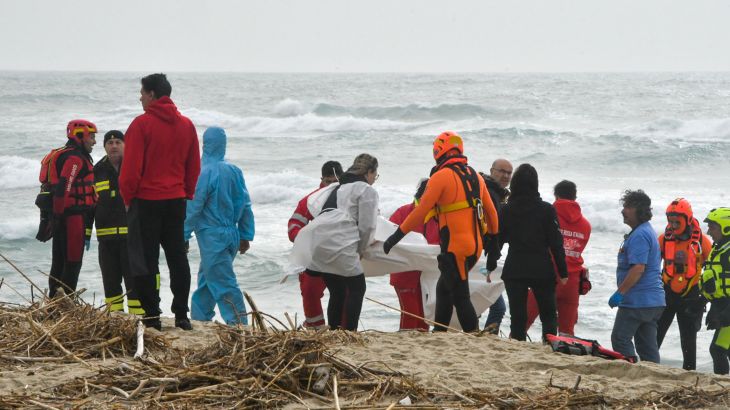 Rescuers recover a body at a beach near Cutro, southern Italy, after a migrant boat broke apart in rough seas