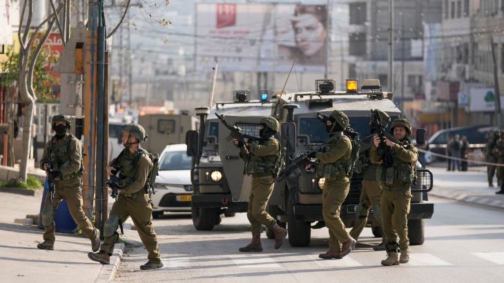 Israeli soldiers take up positions at the scene of a Palestinian shooting attack at the Hawara checkpoint near the occupied West Bank city of Nablus.