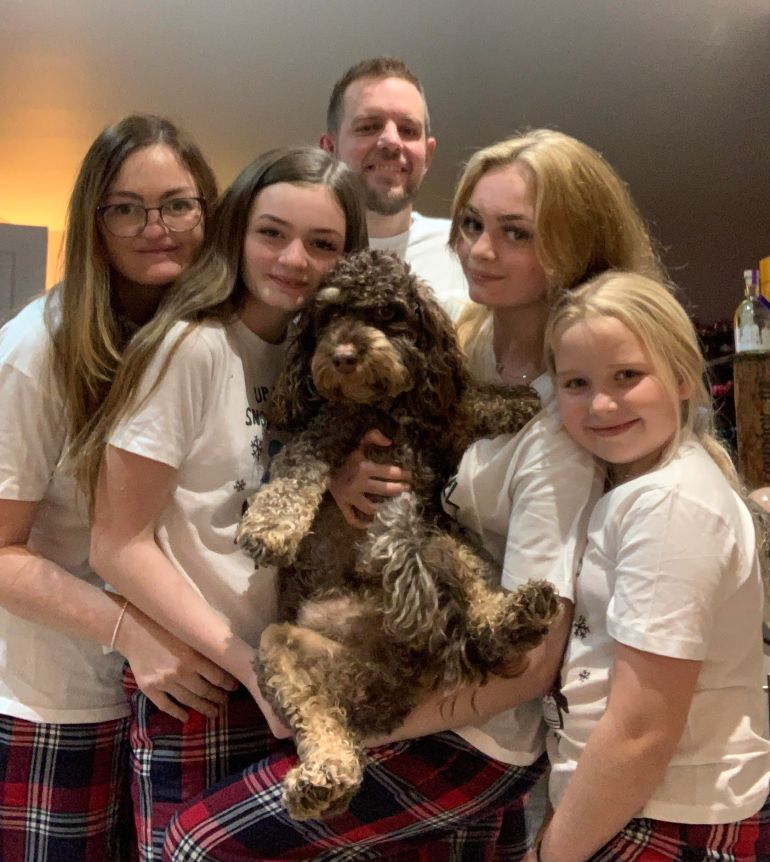 A family in England, including parents, three daughters and a dog