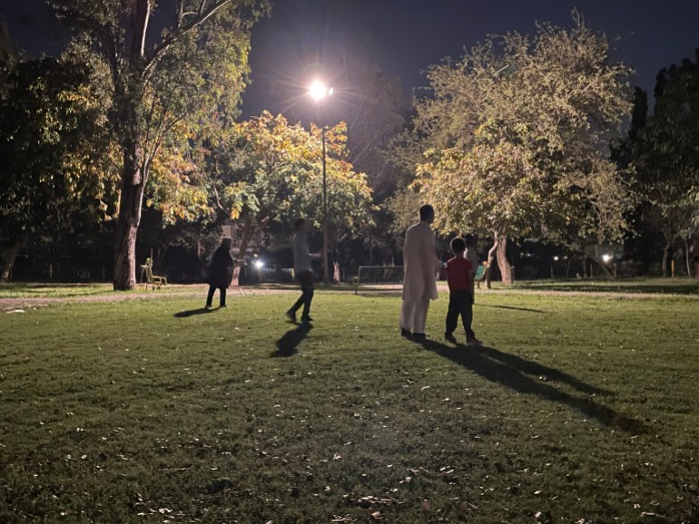 A photo of four people in a park at night.