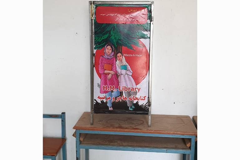 A photo of a metal cupboard, with a mural of Marzia and Hajar Mohammadi.