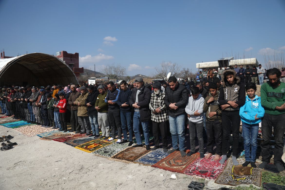 The villagers gathered in a rubble-strewn open area to perform the Friday prayers