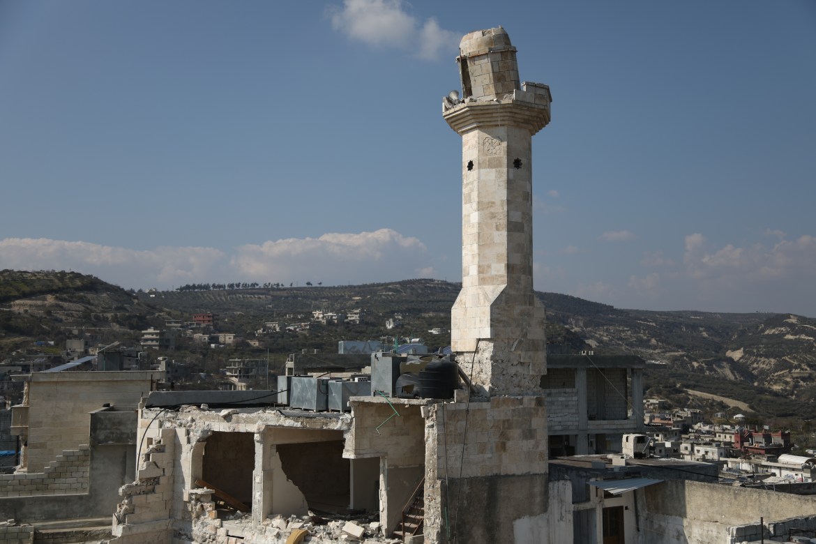 The mosque's broken minaret is shown against the general destruction in the village