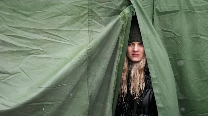 A youth, who fled Ukraine, looks on from inside a tent after crossing the Moldova-Ukrainian border's checkpoint near the town of Palanca.