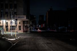 An illuminated signboard on a street corner in Johannesburg.