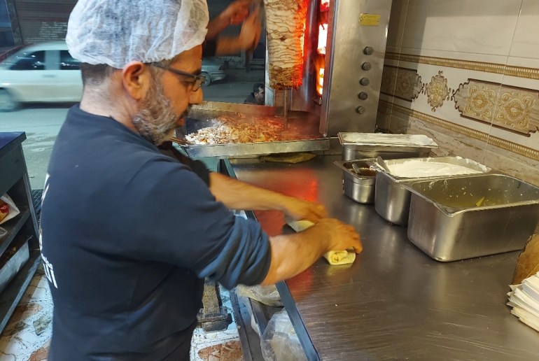 Man making shawarma sandwiches to deliver to rescue workers