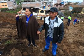 Residents react as they look at the damage caused by the landslide in Alausi, central Ecuador [Jose Jacome/EPA]