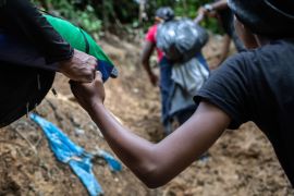 A Colombian guide helps a Haitian woman up a steep mountain slope near Colombia&#39;s border with Panama on October 20, 2021 in the Darien Gap, Colombia [FILE: John Moore/Getty Images]