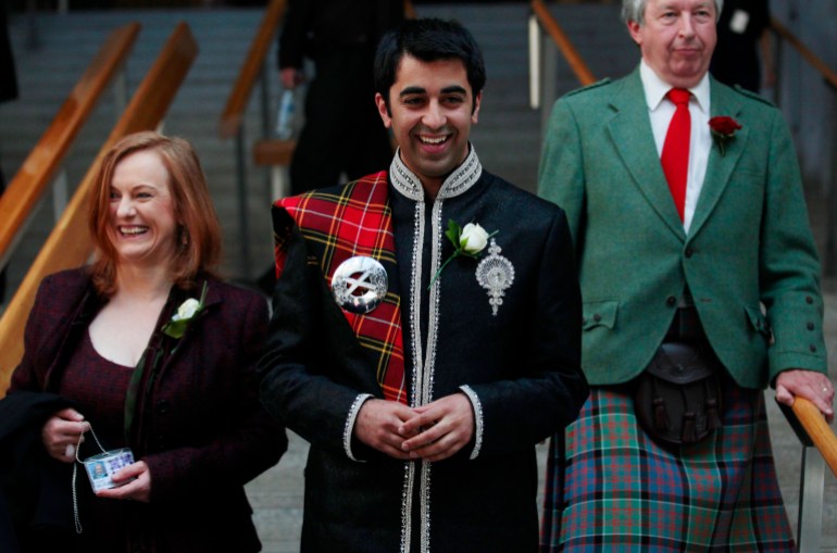 Newly elected Scottish National Party (SNP) Member of Scottish Parliament (MSP) Humza Yousaf (C), smiles as he walks down stairs after the Oath and Affirmation ceremony the Scottish Parliament in Edinburgh, Scotland May 11, 2011. The SNP won sixty nine seats in the Scottish parliament election last week making it the first majority government since devolution began. REUTERS/David Moir (BRITAIN - Tags: POLITICS)