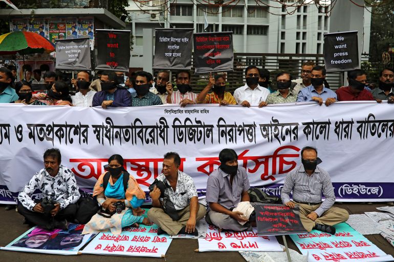 Journalists hold banners and placards as they protest against the newly passed Digital Security Act in front of the Press Club in Dhaka
