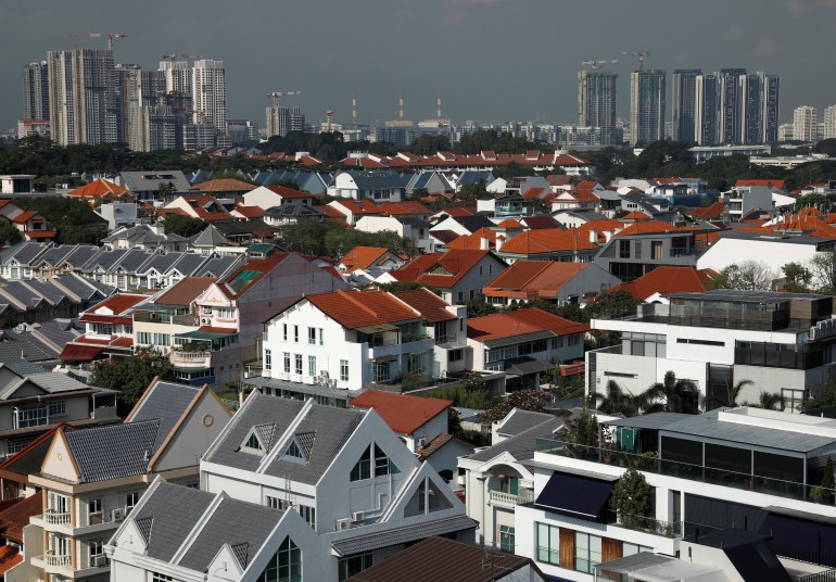 Singapore property with multi-dwelling houses in the foreground and multi-storeyed buildings off in the distance.
