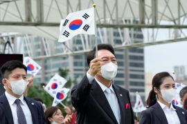 South Korean President Yoon Suk-yeol waves a national flag.