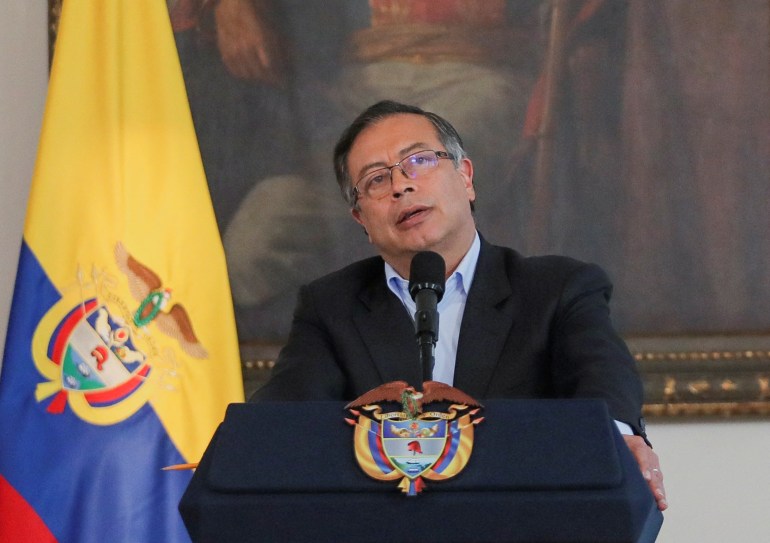 Gustavo Petro berbicara di podium di depan lukisan dan bendera Kolombia