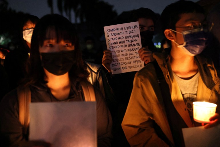 Students gather in Taiwan in support of China's anti-COVID protests. They are holding up white pieces of paper and are carrying candles.