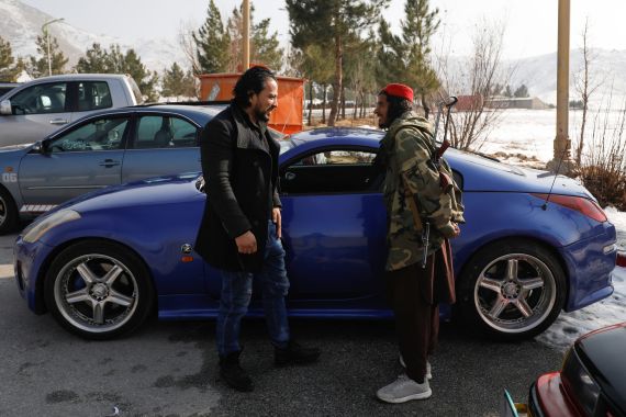 An Afghan man talks to a Taliban soldier next to a car during a race in Kabul, Afghanistan, January 20, 2023. REUTERS/Ali Khara
