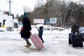 Asylum seekers arrive by taxi to cross from the United States to Canada on Roxham Road in Champlain, New York [File: Christinne Muschi/Reuters]