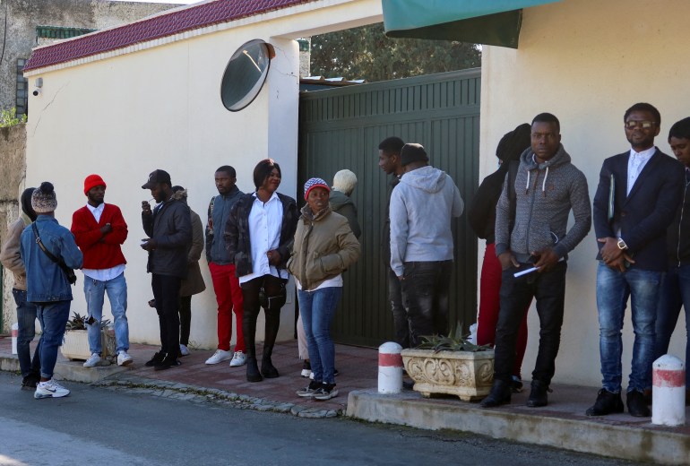 Ivory Coast nationals living seeking repatriation wait outside their country's embassy in Tunis.