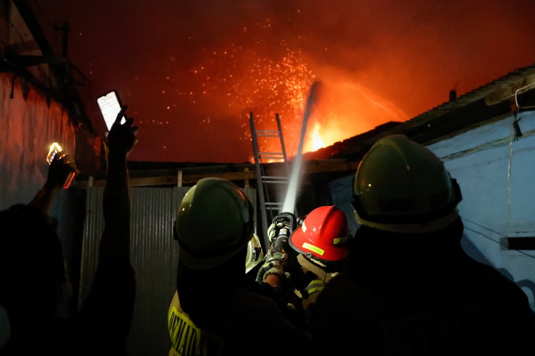 Firefighters try to extinguish a fire at a fuel storage station operated by Indonesia's state energy company Pertamina