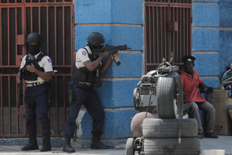 Police officers take position as they fight gangs in Port-au-Prince, Haiti