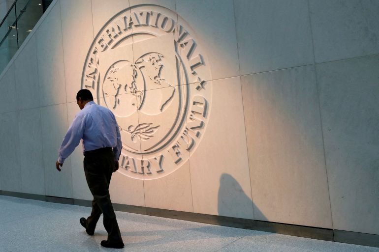 FILE PHOTO: A man walks past the International Monetary Fund (IMF) logo at its headquarters in Washington, U.S., May 10, 2018. REUTERS/Yuri Gripas/File Photo