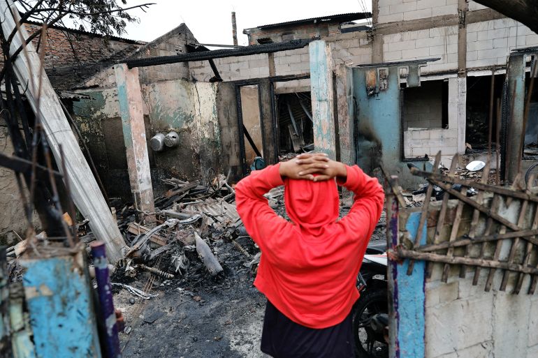A resident reacts as he visits his neighbourhood in Jakarta after a fire