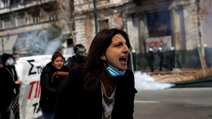 A protester reacts as clashes take place during a demonstration following the collision of two trains, near the city of Larissa, in Athens, Greece