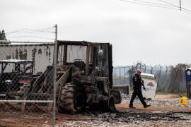 An Atlanta police officer walks by a burned tractor at the site of the proposed Atlanta Public Safety Training facility.