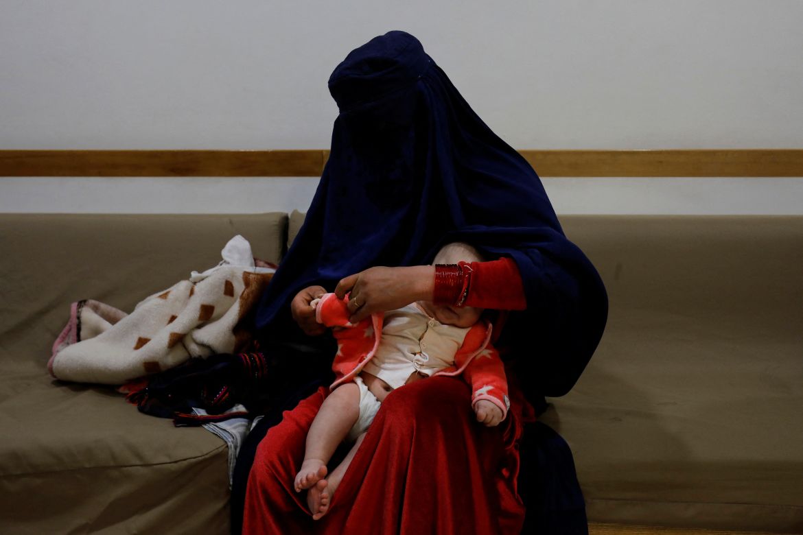 A woman dresses up her child at a hospital in Bamiyan, Afghanistan