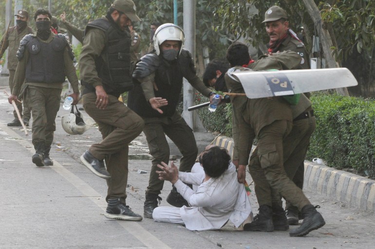 Police officers detain a supporter of former Prime Minister Imran Khan in Lahore.