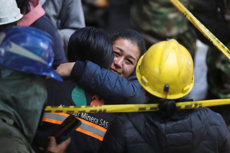 A woman reacts as rescue personnel search for survivors from a mine blast in Colombia