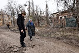 A Ukrainian volunteer tries to convince a resident to evacuate from near the front line, in Chasiv Yar [Violeta Santos Moura/Reuters]