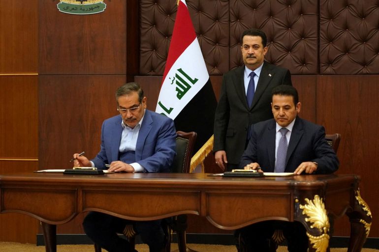 Iraqi Prime Minister Mohammed Shia al-Sudani looks on as Iraq's National Security Adviser Qasim al-Araji and Iran's Supreme National Security Council secretary Ali Shamkhani sign the security agreement that includes coordination in protecting the common borders between the two countries, in Baghdad, Iraq, March 19, 2023. Iraqi Prime Minister Media Office/Handout via REUTERS ATTENTION EDITORS - THIS IMAGE WAS PROVIDED BY A THIRD PARTY.