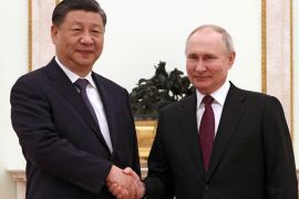 Chinese President Xi Jinping and Russian President Vladimir Putin shake hands during a meeting at the Kremlin in Moscow [Sputnik/Pool via Reuters]