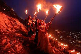 Iraqi Kurdish people carry fire torches, as they celebrate Nowruz, a festival marking the first day of spring and the new year, in the town of Akra near Duhok [File: Alaa Al-Marjani/Reuters]