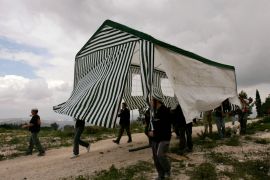Israeli activists carry a tent in the abandoned Jewish settlement of Homesh, in the northern West Bank [File: Ronen Zvulun/Reuters]