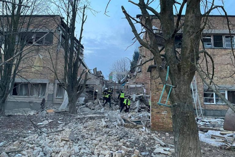 Rescuers and police officers work at a site of a building of the local lyceum heavily damaged by a Russian drone strike, amid Russia's attack on Ukraine, in the town of Rzhyshchiv, in Kyiv region, Ukraine March 22, 2023. Press service of the Kyiv Regional Prosecutor's Office/Handout via REUTERS ATTENTION EDITORS - THIS IMAGE HAS BEEN SUPPLIED BY A THIRD PARTY. NO RESALE. NO ARCHIVE.