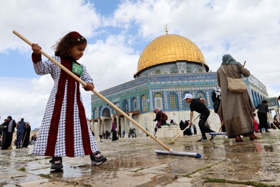 A Palestinian girl cleans the stone of the compound known to Muslims as the Noble Sanctuary and to Jews as the Temple Mount, in front of the Dome of the Rock, as part of preparations for the holy fasting month of Ramadan in Jerusalem's Old City