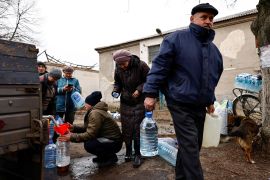 Residents fill up bottles with fresh drinking water brought into Chasiv Yar near Bakhmut, Ukraine, as they try to survive in a war zone with shortages of food and few if any basic services [Violeta Santos Moura/Reuters]