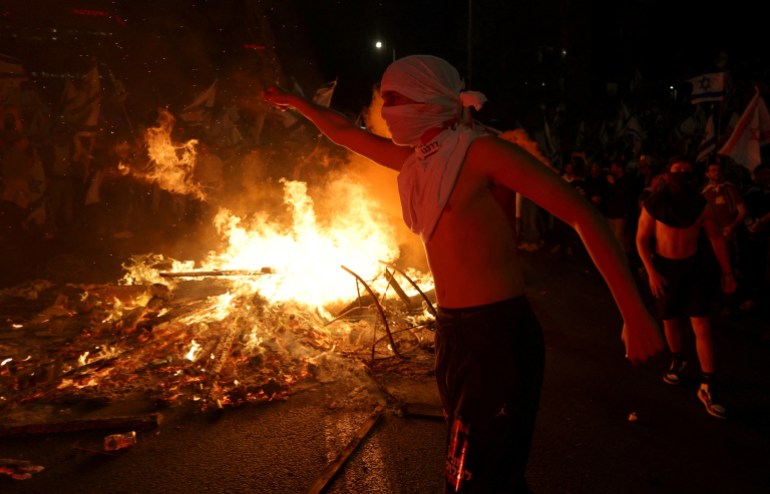 Israeli protesters light a bonfire 