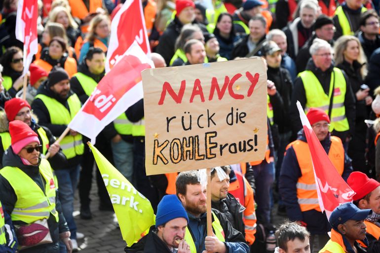 A protestor holds a placard reading 'Nancy (Nancy Feser, German Minister of Interior) give us the money' as people demonstrate in front of 'Landungsbruecken' at the harbour during a nationwide strike called by the German trade union Verdi over a wage dispute in Hamburg, Germany, March 27, 2023. REUTERS/Fabian Bimmer
