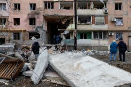 People gather outside a multi-storey apartment block damaged in Donetsk, Ukraine [Alexander Ermochenko/Reuters]