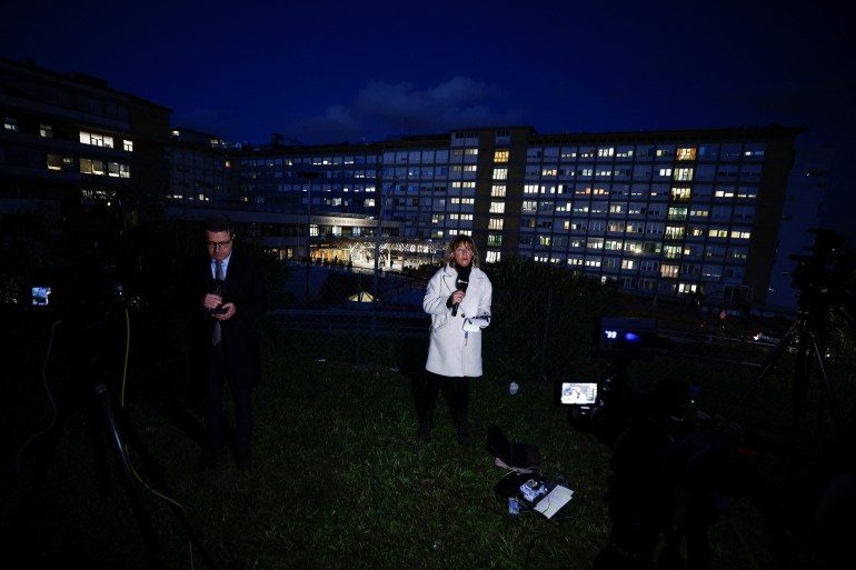 Members of the media report from outside the Gemelli Hospital, where Pope Francis attends a previously scheduled check-up, in Rome, Italy March 29, 2023. REUTERS/Guglielmo Mangiapane