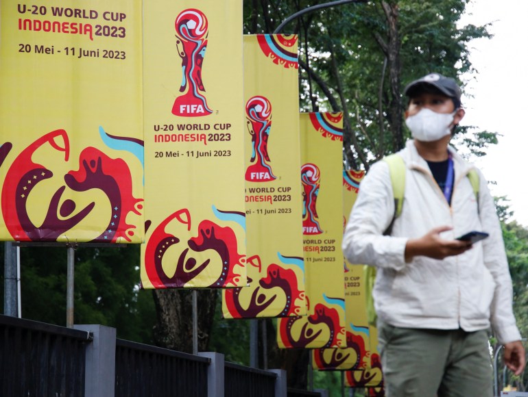  man walks past FIFA U-20 World Cup banners outside Indonesia's football federation (PSSI) office, after the country was dropped as host of the under-20 soccer World Cup, following outrage among politicians in the predominantly Muslim country about Israel's participation, in Jakarta, Indonesia, March 30, 2023. REUTERS/Willy Kurniawan